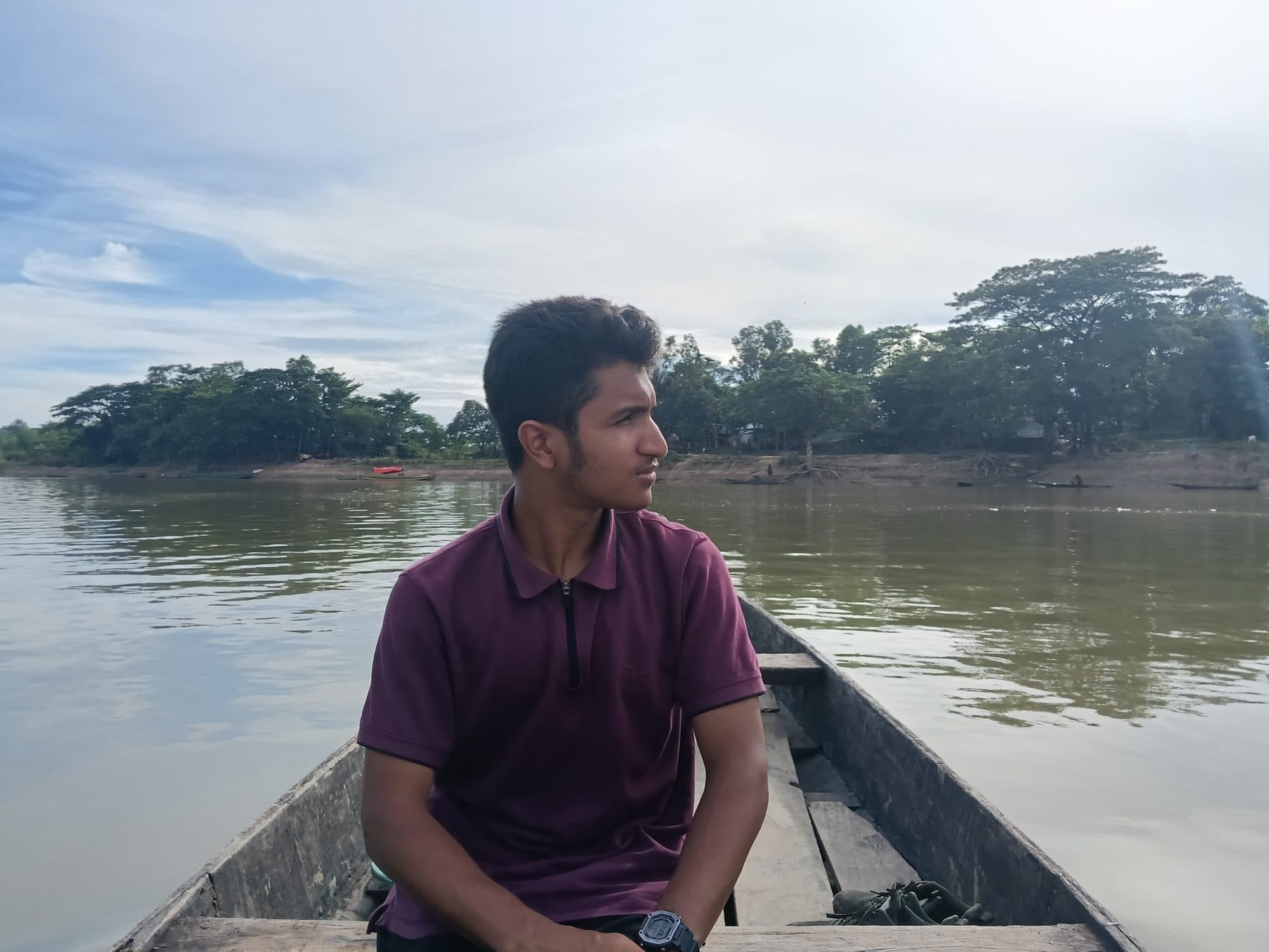 Mohammad Nasir in a wooden boat on a river in Sylhet