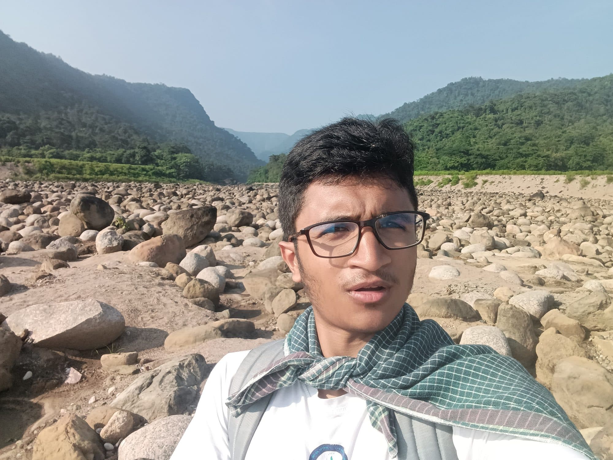 Mohammad Nasir by a stone-filled river in Sylhet