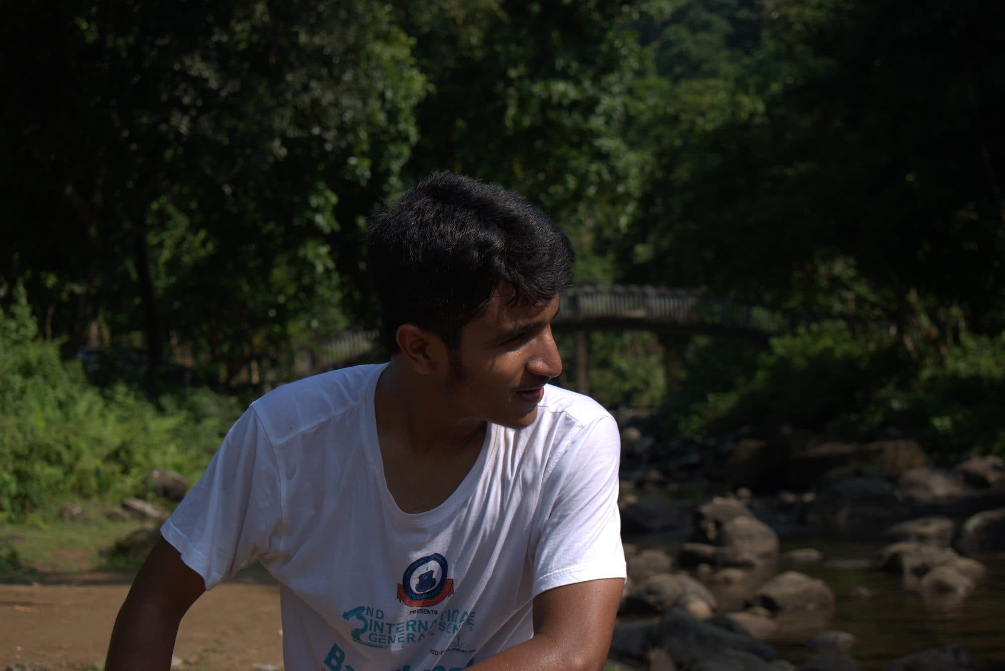 Mohammad Nasir by a forest stream and bridge in Sylhet