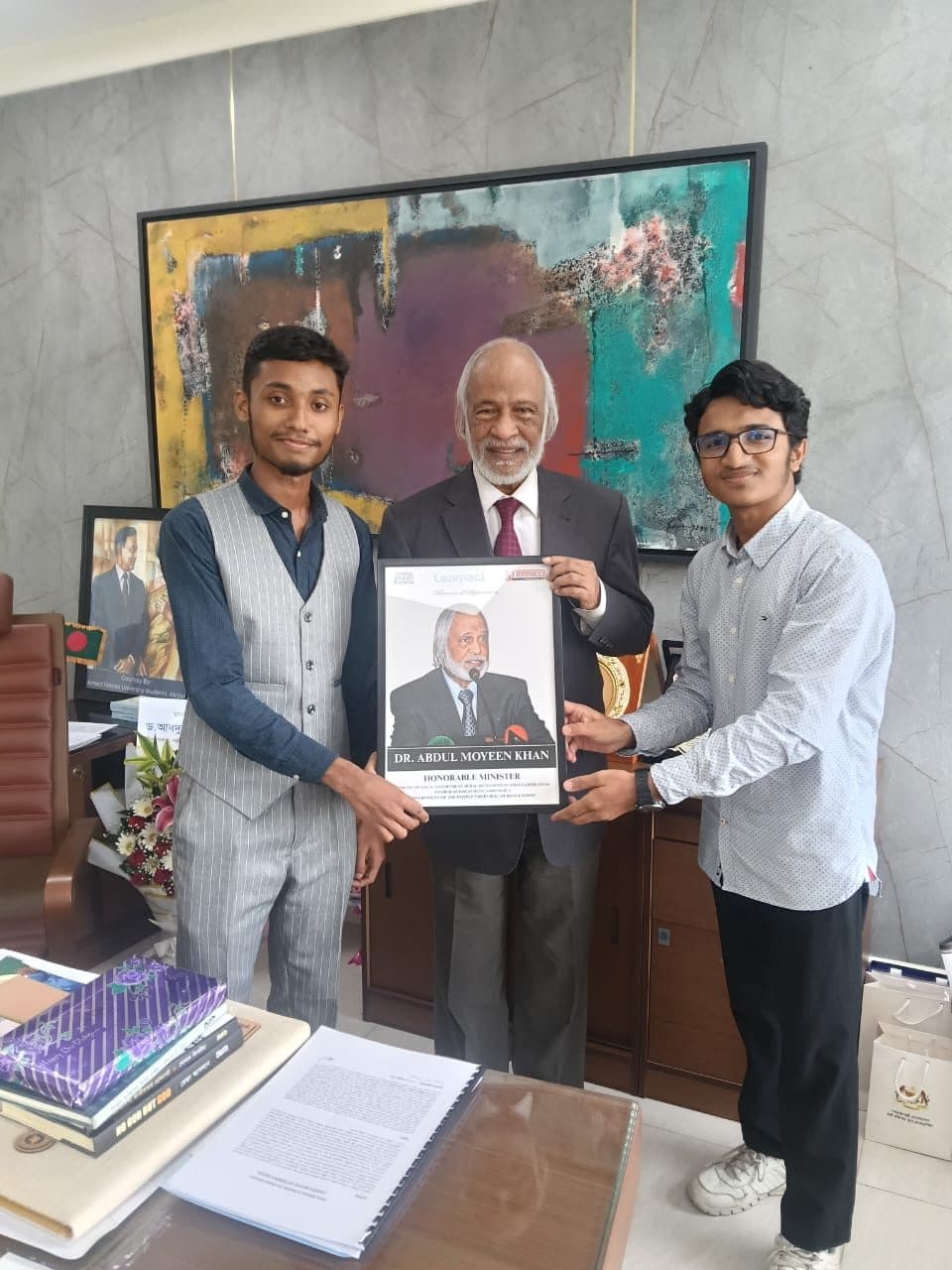 Mohammad Nasir presenting a portrait to Dr. Abdul Moyeen Khan, Minister of Local Government, Rural Development and Co-operatives of Bangladesh