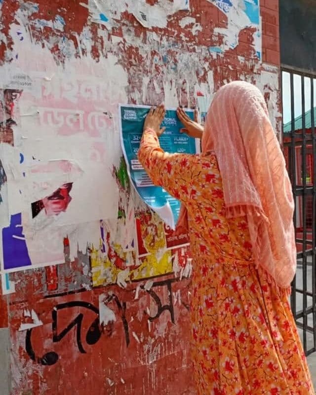 A teacher putting up an olympiad poster