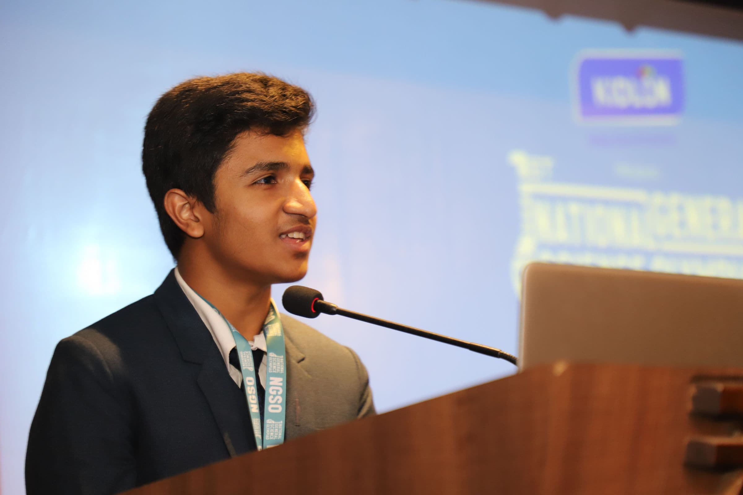 Mohammad Nasir speaking at the podium of the National General Science Olympiad